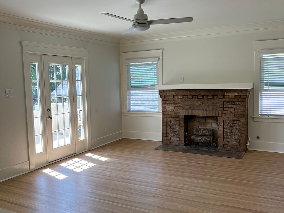 Bright living room with ceiling fan and access to private deck