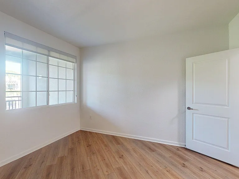 Spacious apartment Bedroom with wood-style flooring and a large window