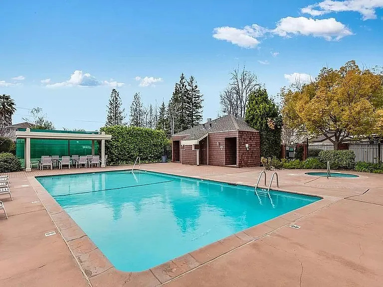 Pool with hot tub facing the tennis court and dining patio area