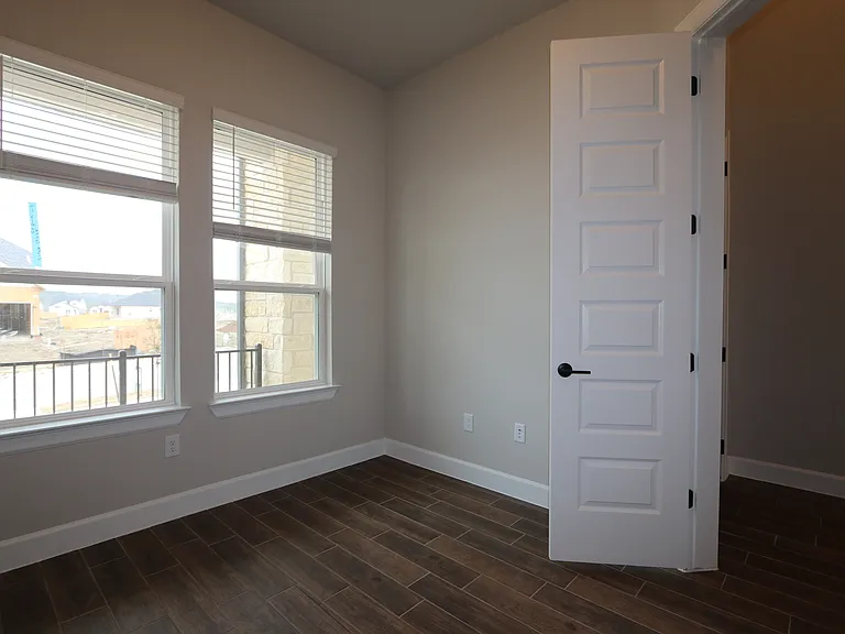 Spacious home office with abundant natural light, stylish board and batten accents, and plenty of room to work or create_perfect for productivity and comfort.