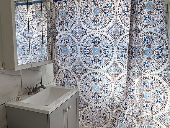 Bright, newly remodeled bathroom with new tile, vanity and toilet.