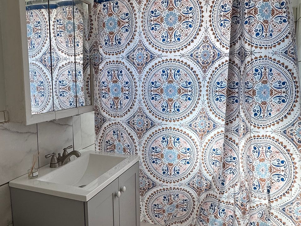 Bright, newly remodeled bathroom with new tile, vanity and toilet.