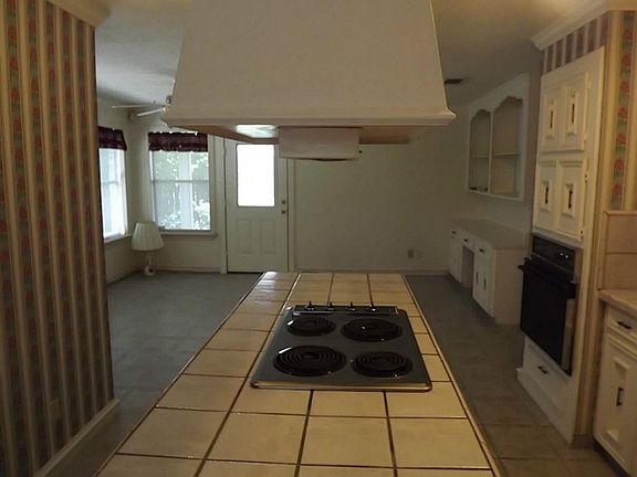 Island kitchen with a 4 burner electric stove top and abundant workspace for the creative chef