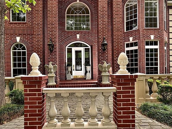 The stately front entrance features a solid wood, white door with leaded glass insert, sidelights and arched transom.