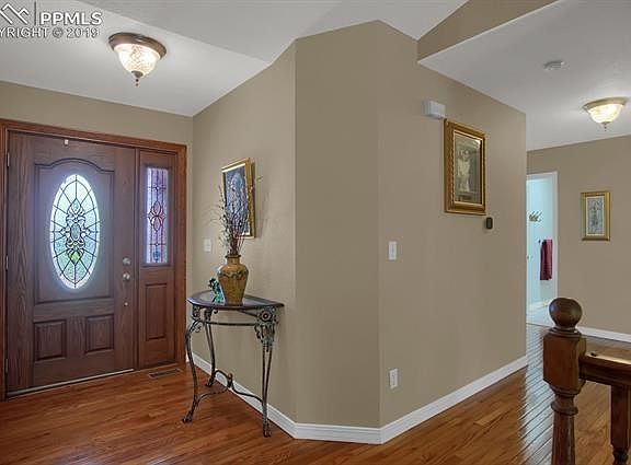 Custom stained glass front door entry, with wood floors and access to 3 bedrooms (including master) and full bath
