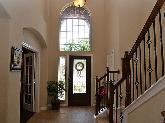 Elegant entry with a beveled glass front door, tile floors, two story high ceilings and crown molding.