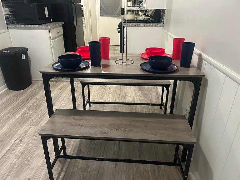 Eat-in kitchen nook features a sturdy table with bench seating, set beside a full kitchen for easy shared meals.