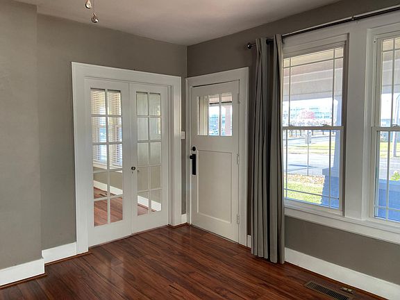 FRONT DOOR IN LIVING ROOM. DOUBLE DOORS LEAD TO FRONT BEDROOM.