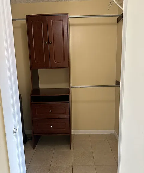 Walk in closet with storage cabinet.