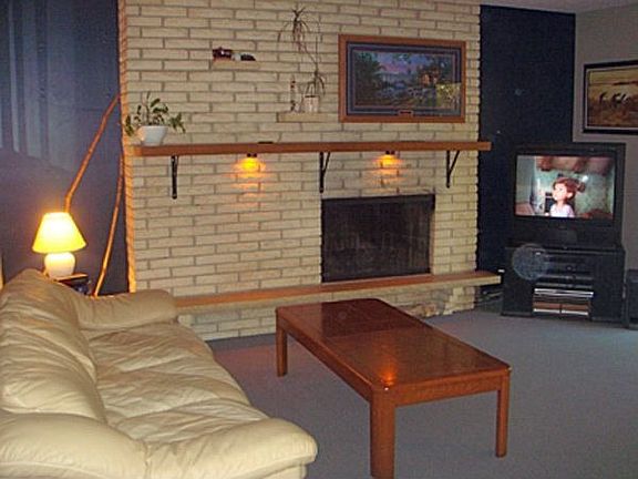 Living room with patio doors to deck and wood burning fireplace.