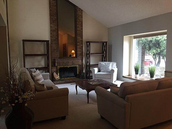 Formal living room with wood burning fireplace, vaulted ceilings and new picture window