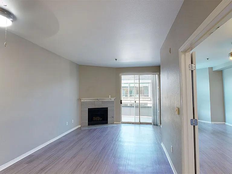 Apartment living room with wood-style flooring and patio or balcony in select homes.