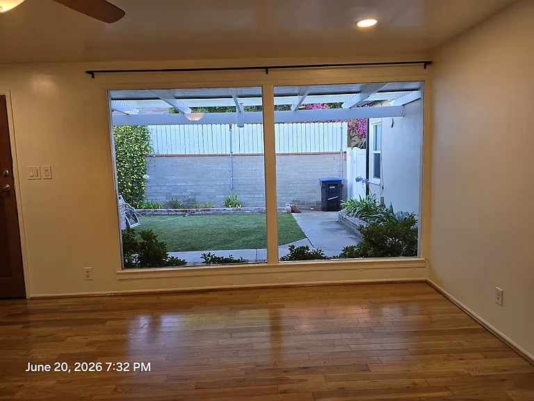 From inside living room looking out over tall private fencing, and gated yard
