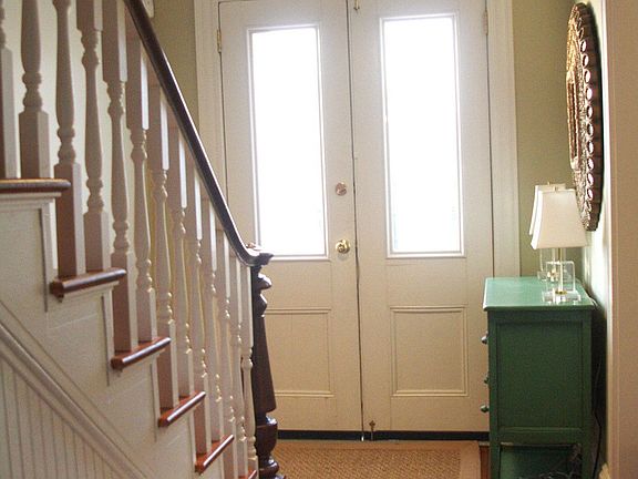 Sun-filled entry with original doors and transom