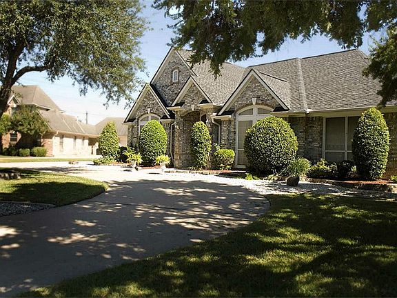  The front of this home boasts curb appeal with a beautifully curved driveway and lush landscaping. The shade trees add a gorgeous ambiance.