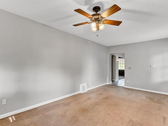 Roomy living room with lots of natural light and ceiling fan