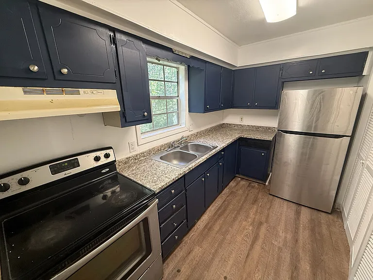 Kitchen features stainless steel stove and fridge