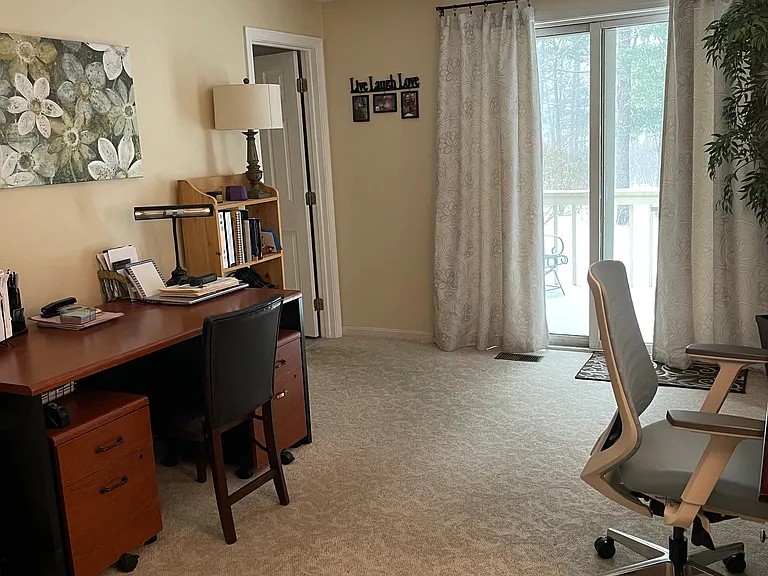 Downstairs master bedroom, attached to the full bath (door to the left), currently being used as an office. There are 2 double closets behind me in this picture. View out of all the windows and slider is stunning. Carpet has been replaced since this photo