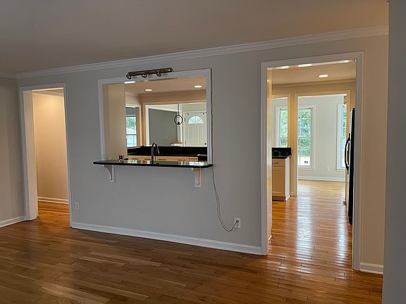 Front room open to kitchen. Cased opening on left leads to powder room and laundry room area. On the right you can turn to the hallway which leads to the bedrooms.