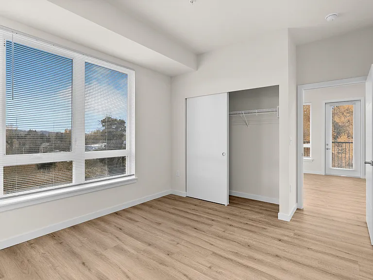 Sun-filled bedroom with wood-style floors and a spacious sliding-door closet. Sun-filled bedroom with wood-style floors and a spacious sliding-door closet.