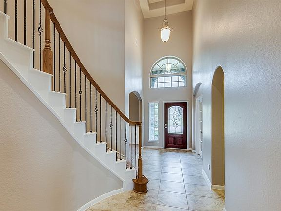 VIEW OF THE 2 STORY FOYER AND WINDING STAIRCASE.