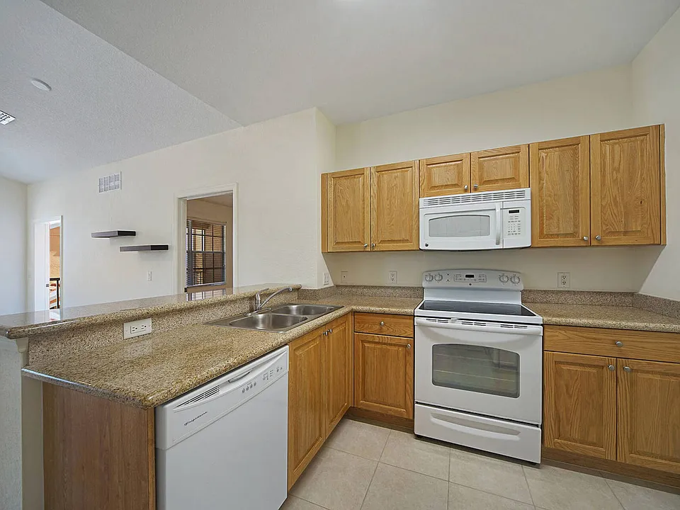 Kitchen w/ granite counters and wooden cabinets