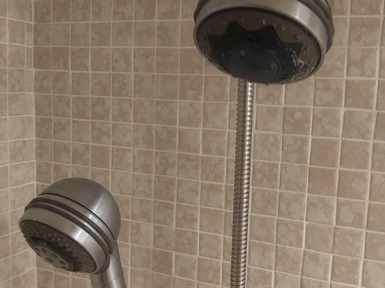 operate diverter on side of fixed shower head to contol water flow from wither fxed or hand shower or both shower heads.