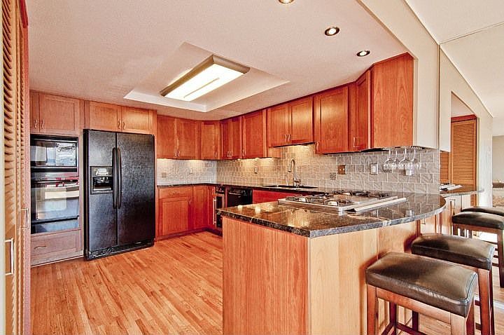 Beautiful remodeled kitchen with wine fridge, gas cook top, lots of storage, glass tile backsplash, and granite slab counters with eating bar!