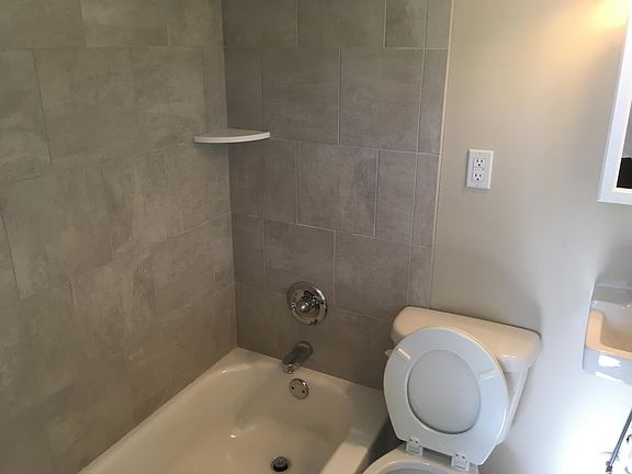 Fully renovated bath including tile surround tub.