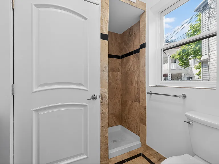 First floor full bath featuring very rare Italian travertine tiles.