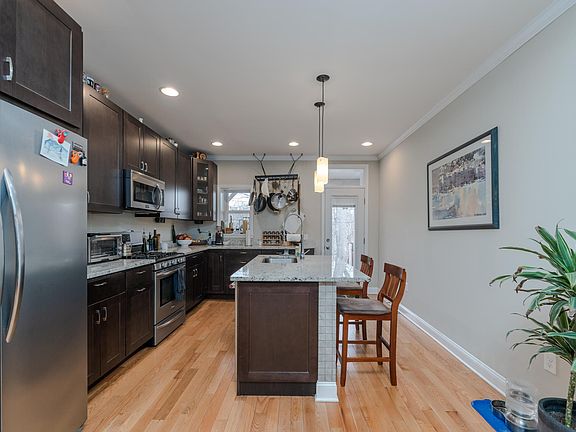 Modern kitchen with new appliances, island counter with seating and granite counters