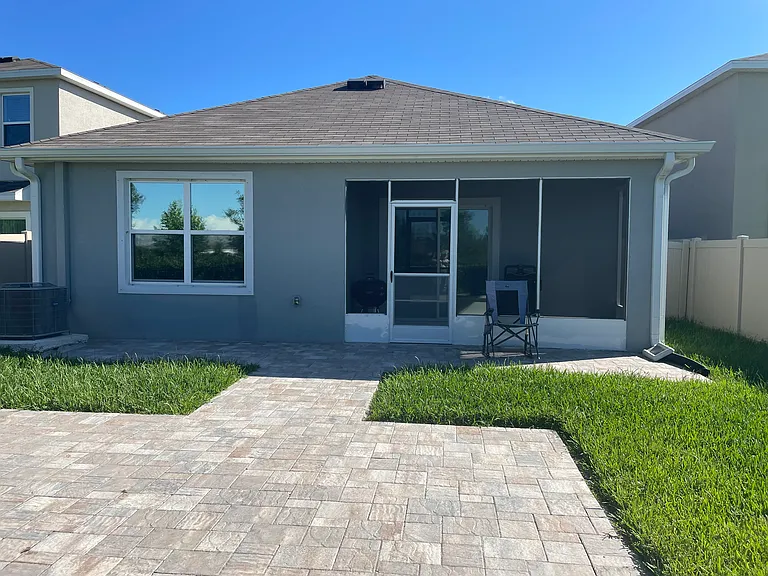 back of the house: screened lanai, paved yard