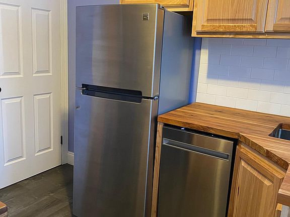 Stainless fridge and dishwasher with door to basement