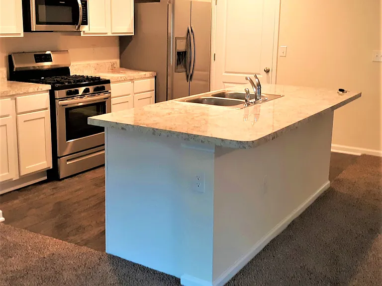 Kitchen island, appliances and door to large pantry