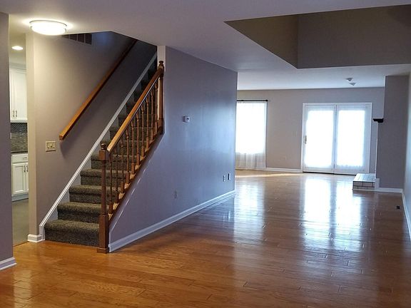 First floor, open plan. From front door area, facing into the living space. Kitchen to the left of the stairs.