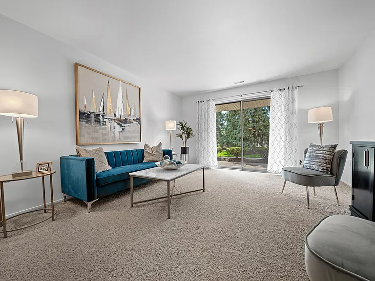 Spacious Living room with patio at Prentiss Pointe Apartments in Harrison Township