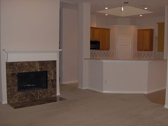 Den w/ Fireplace Leading to Kitchen