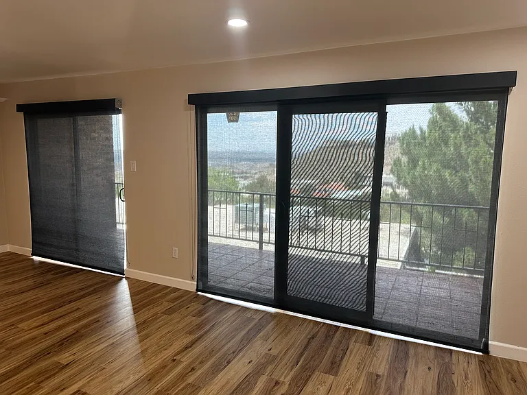 Living room looking out towards the balcony with solar shades closed