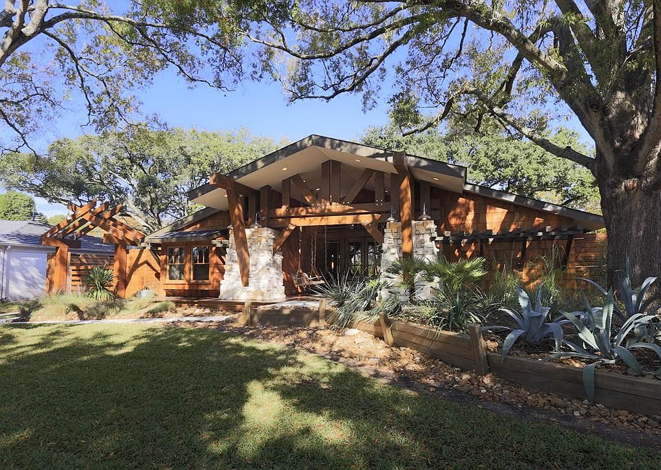 Beautifully landscaped front yard with mature trees.