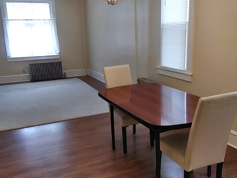 Another, furnished view of the large (approximately 27 x 13 feet) living room / dining room combination space. The front half of the room is considerably wider than this photo captures. View from the kitchen door.