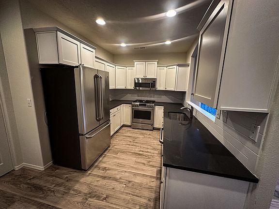 Kitchen with stainless steel appliances, lots of cabinets and kitchen pantry.