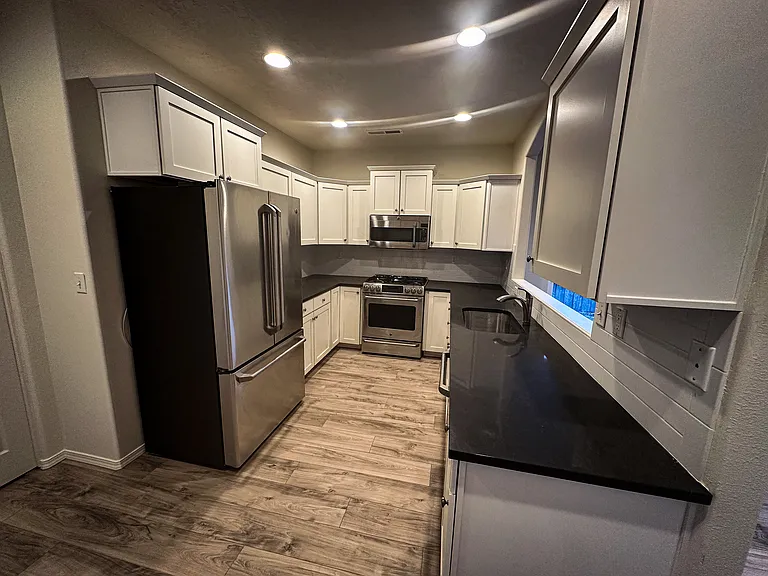 Kitchen with stainless steel appliances, lots of cabinets and kitchen pantry.