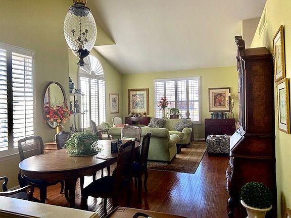 Living/dining area with wood shutters, cathedral ceilings and gas fireplace. Hardwood floors throughout first floor living area