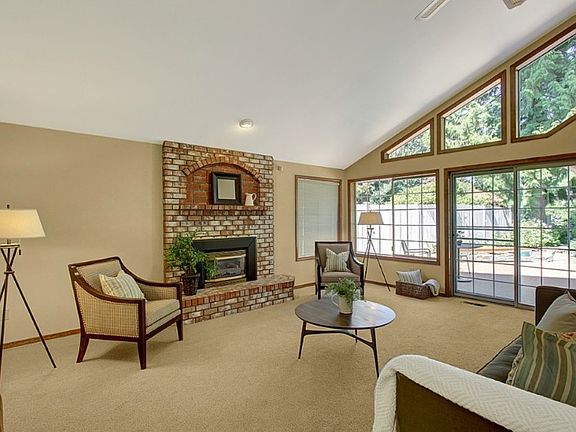 Inviting great room with vaulted ceilings, numerous large windows and designer colors which is open to the kitchen and a dining room.