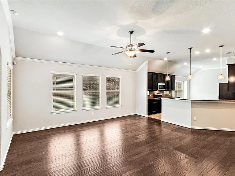 Open-concept living space featuring wood-finish flooring, vaulted ceilings, and recessed lighting