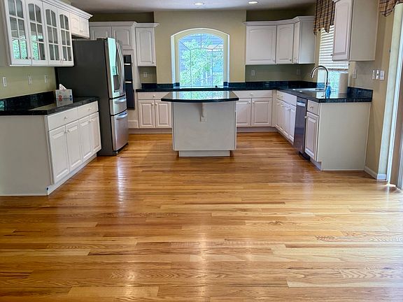 large kitchen with stainless steel appliances and many cabinets