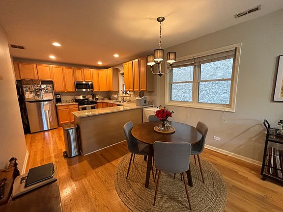Kitchen with stainless steel appliances and granite counters. Additional space for dining table.