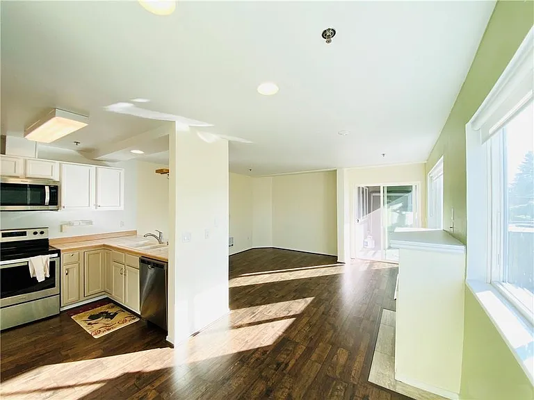 View of kitchen, living area and slider to deck.