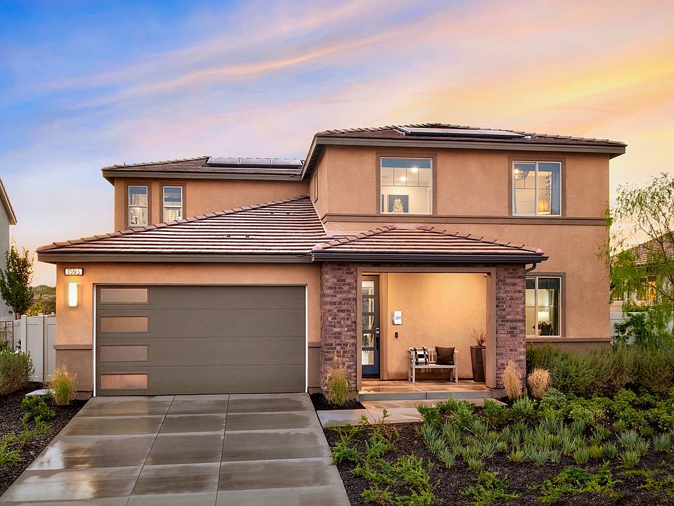 A two-story residential house with a garage, surrounded by a well-maintained landscaped yard, set ag