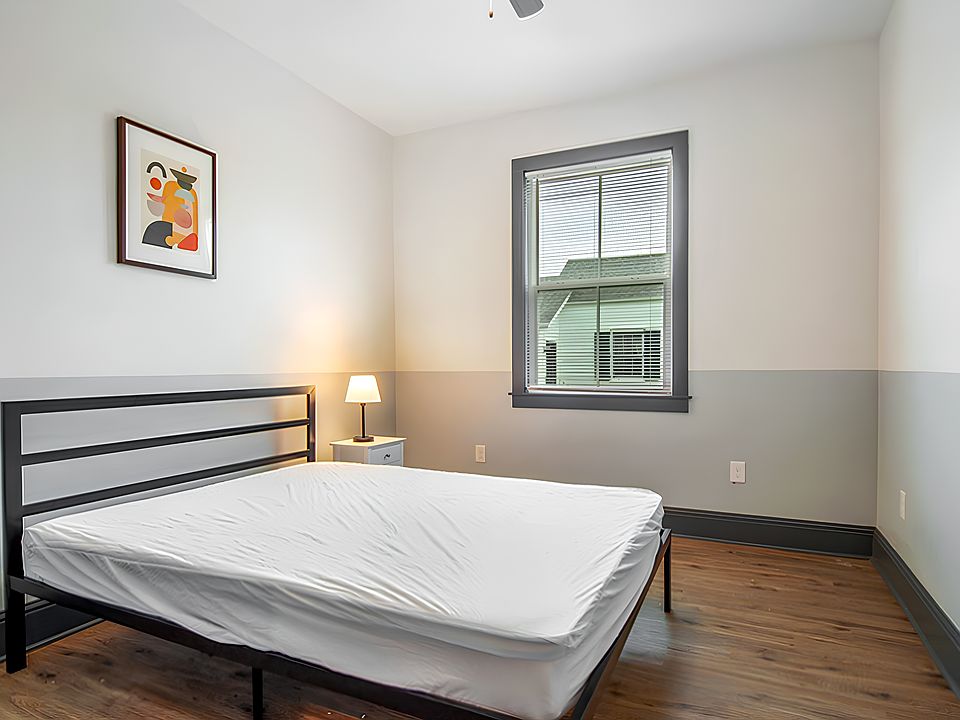 Spacious furnished room with queen size bed, ceiling fan, nightstand